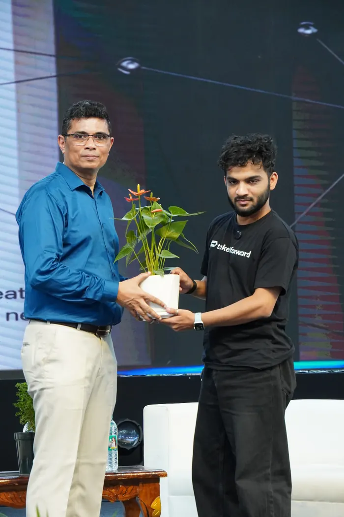 Striver being welcomed on stage with a potted plant